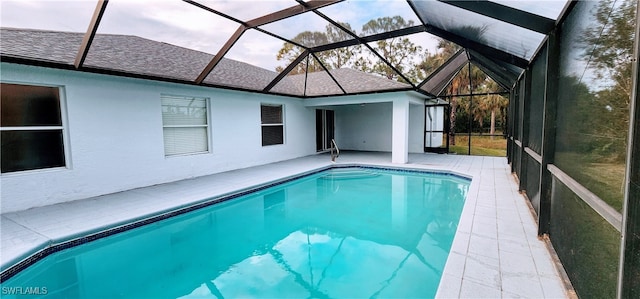 view of swimming pool with glass enclosure and a patio