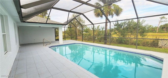 view of swimming pool featuring glass enclosure and a patio area