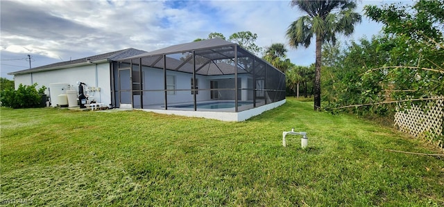 back of house with a lanai and a yard