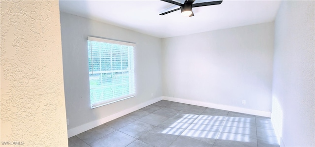 tiled spare room with ceiling fan