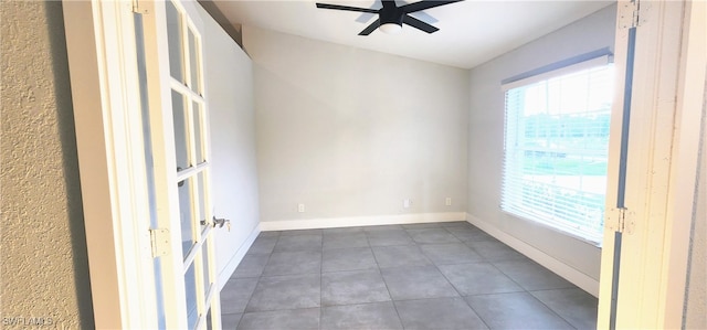 tiled empty room featuring ceiling fan