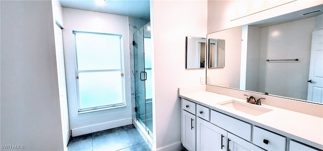 bathroom featuring tile patterned floors, vanity, and a shower with shower door