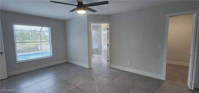 spare room with ceiling fan and light tile patterned flooring