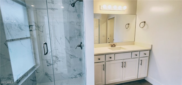 bathroom featuring a shower with door and vanity