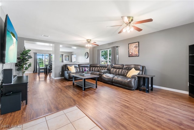 living room with ceiling fan, light wood-type flooring, and a healthy amount of sunlight