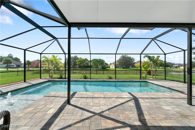 view of pool with pool water feature, glass enclosure, a lawn, and a patio area