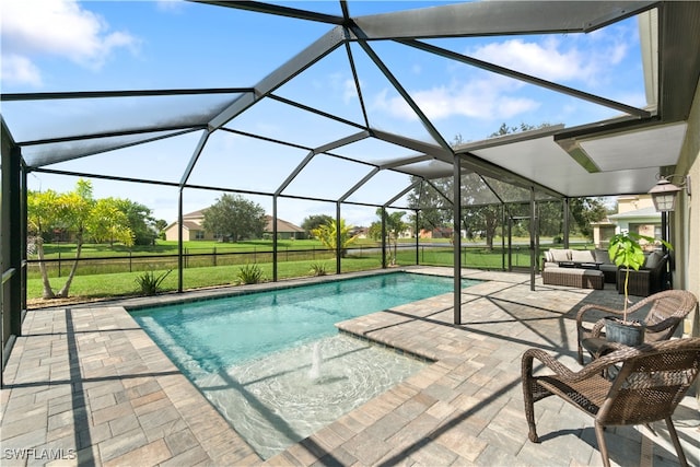 view of pool with glass enclosure, a lawn, an outdoor hangout area, and a patio area