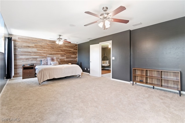 bedroom featuring ceiling fan, light colored carpet, and wooden walls