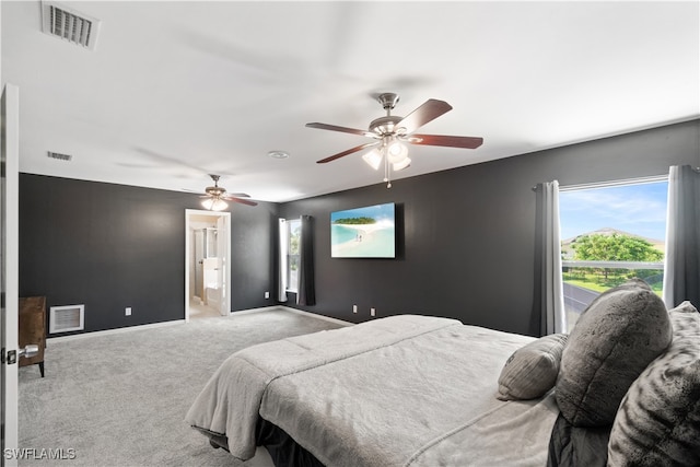 bedroom featuring light carpet, ensuite bath, and ceiling fan