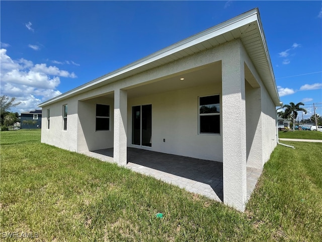 back of property with a yard and a patio area