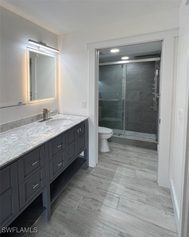 bathroom featuring vanity, an enclosed shower, and toilet