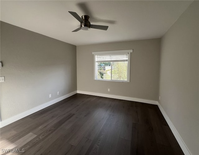 spare room with dark hardwood / wood-style floors and ceiling fan