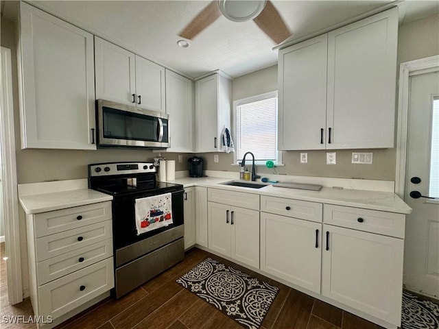 159 Pearl St, Fort Myers Beach, FL 33931 - kitchen with a sink, dark wood-style floors, white cabinets, and stainless steel appliances