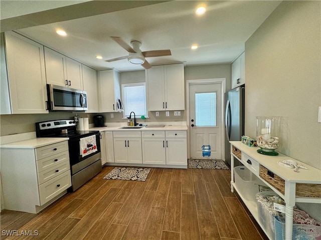 159 Pearl St, Fort Myers Beach, FL 33931 - kitchen with dark wood finished floors, white cabinetry, a ceiling fan, and appliances with stainless steel finishes