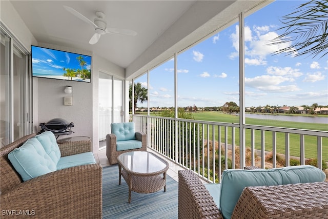 sunroom / solarium with a water view and ceiling fan