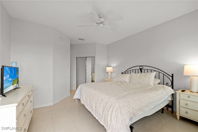 bedroom with a closet, light tile patterned flooring, and ceiling fan