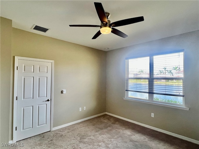 carpeted spare room with ceiling fan