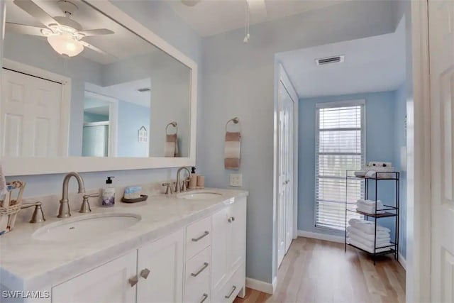 bathroom featuring a shower with door, vanity, hardwood / wood-style floors, and ceiling fan