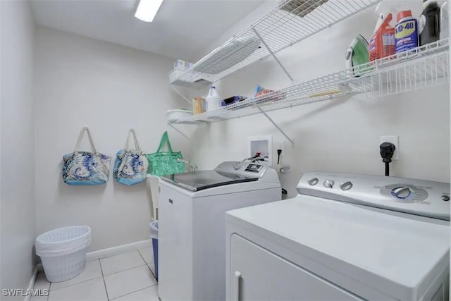 laundry room with light tile patterned floors and washer and clothes dryer