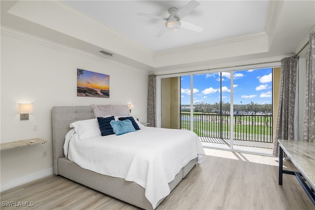 bedroom featuring access to exterior, ceiling fan, a raised ceiling, crown molding, and light hardwood / wood-style floors