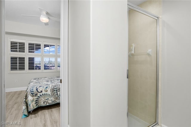 bathroom with walk in shower, ceiling fan, and hardwood / wood-style flooring