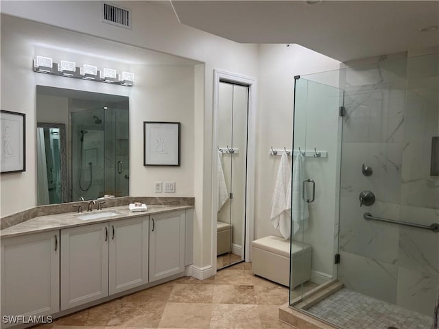 bathroom featuring visible vents, vanity, and a marble finish shower