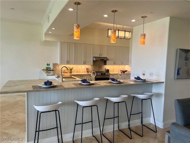 kitchen featuring under cabinet range hood, a peninsula, a sink, electric stove, and tasteful backsplash