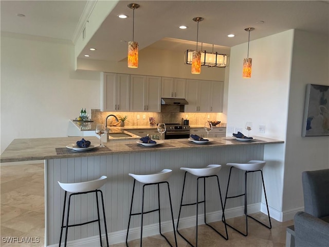 kitchen with tasteful backsplash, a peninsula, stainless steel range with electric stovetop, under cabinet range hood, and a sink