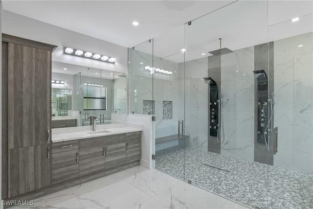 bathroom with vanity, a shower with door, and tile walls