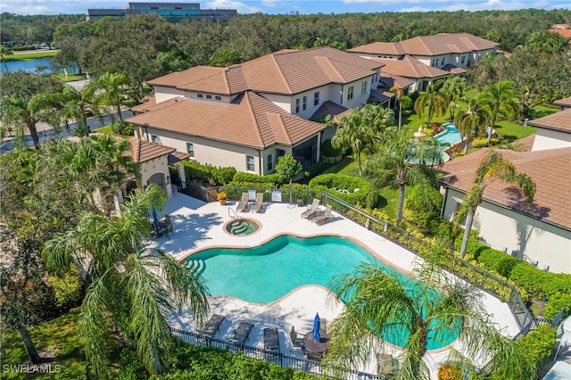 pool featuring a community hot tub, a patio, and fence