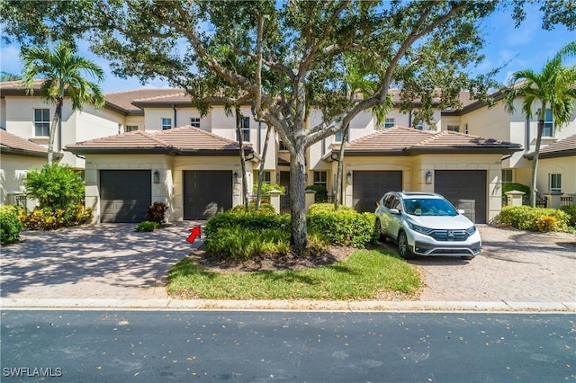 view of front of property with a garage, decorative driveway, and a tile roof