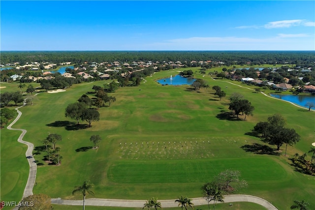 drone / aerial view featuring golf course view and a water view