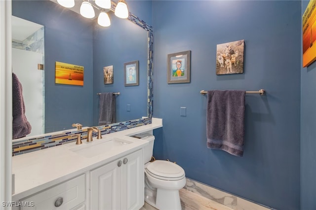 bathroom featuring toilet, decorative backsplash, and vanity