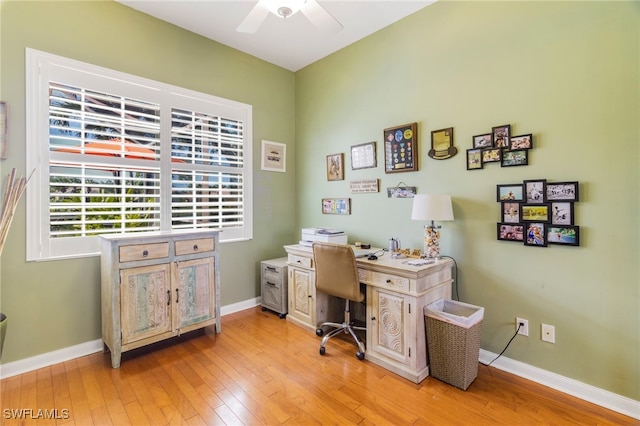 office with light wood-type flooring and ceiling fan