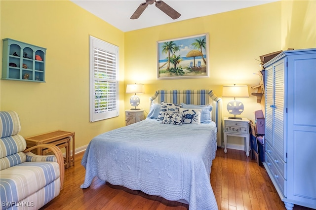 bedroom with dark hardwood / wood-style floors and ceiling fan