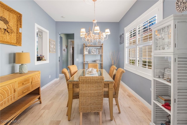 dining area featuring light hardwood / wood-style floors and a notable chandelier