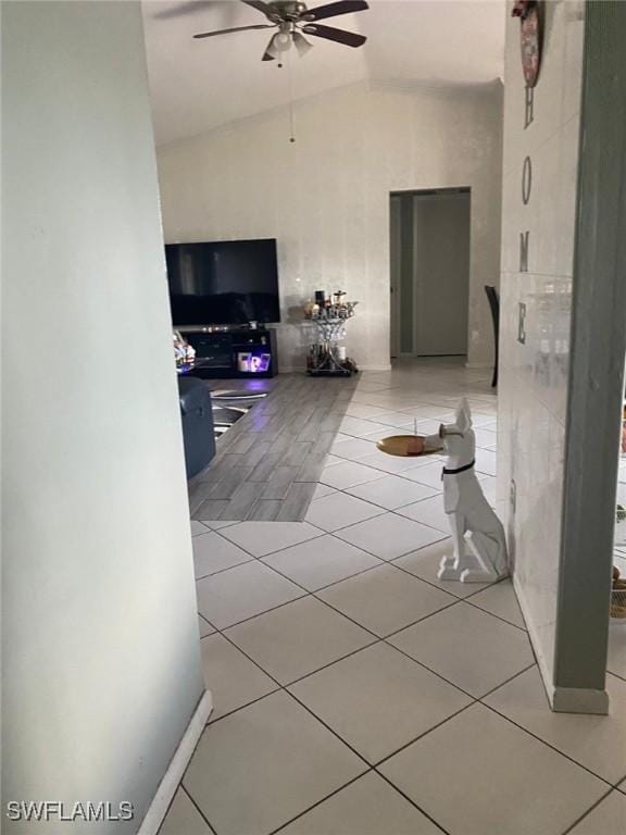 hallway with light tile patterned flooring and lofted ceiling