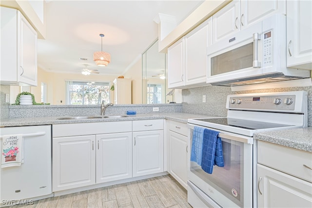 kitchen with white cabinets, tasteful backsplash, light hardwood / wood-style floors, crown molding, and white appliances