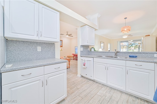 kitchen with white cabinets, hanging light fixtures, white dishwasher, ornamental molding, and sink