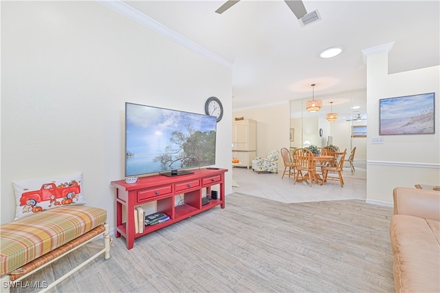 living room featuring light hardwood / wood-style floors, ornamental molding, and ceiling fan