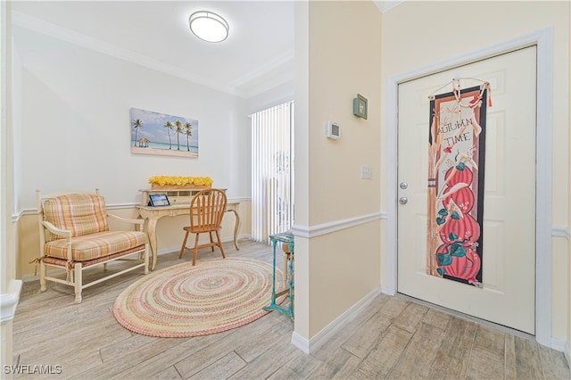 foyer entrance with crown molding and light hardwood / wood-style flooring