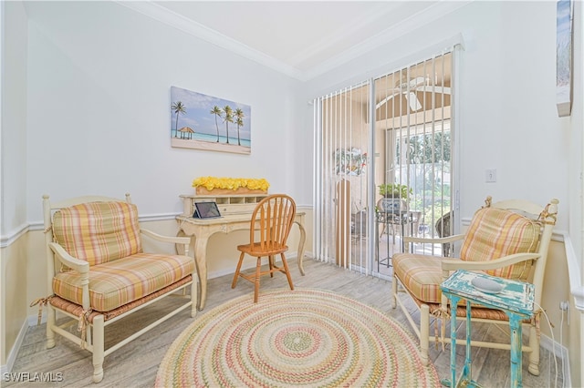 sitting room with light hardwood / wood-style floors and crown molding