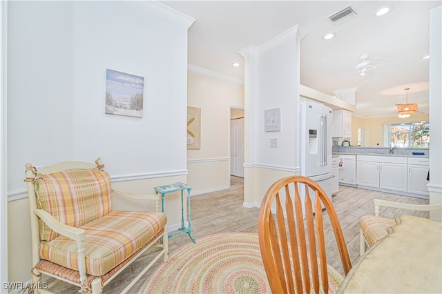 dining area with ornamental molding, sink, light hardwood / wood-style flooring, and ceiling fan