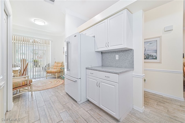 kitchen featuring high end white fridge, white cabinetry, tasteful backsplash, and light wood-type flooring