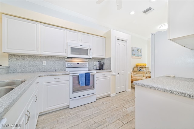 kitchen with light hardwood / wood-style flooring, backsplash, ornamental molding, white cabinets, and white appliances