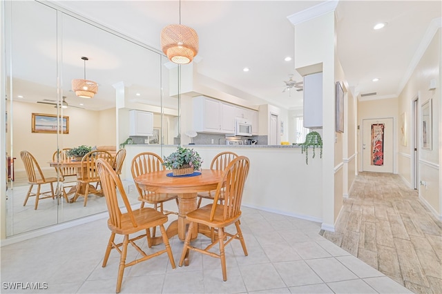 dining room featuring crown molding, light wood-type flooring, and ceiling fan