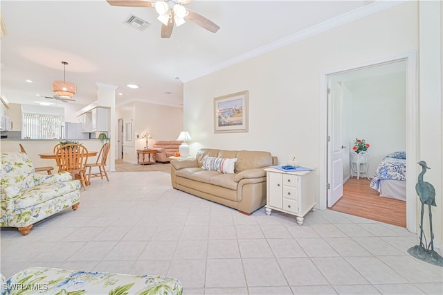 tiled living room with ornamental molding and ceiling fan