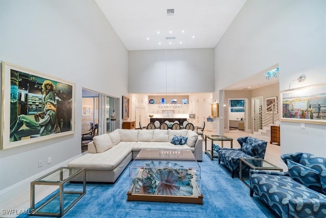 carpeted living room featuring a high ceiling