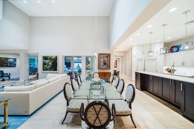 dining space with sink and a towering ceiling