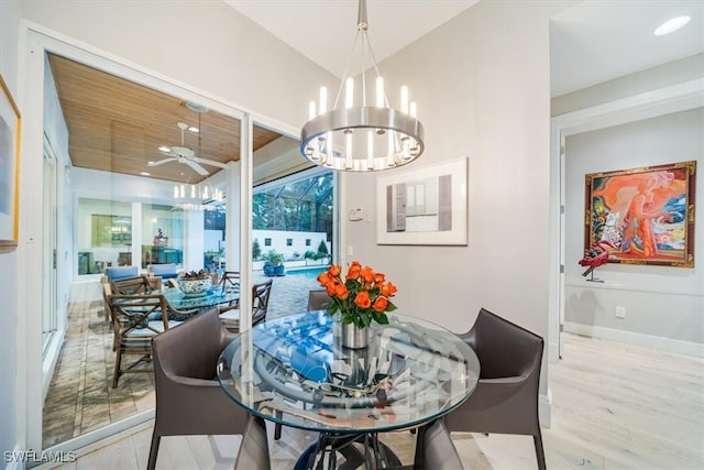 dining room with light wood-type flooring and ceiling fan with notable chandelier